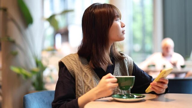 young asian woman drinking coffee on work break