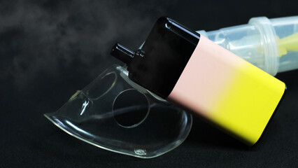 Electronic cigarette and inhalation mask on black background