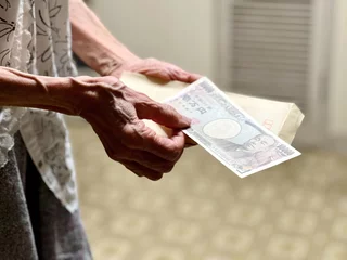 Foto op Plexiglas 封筒と1万円札を持つ高齢女性の手元 © smile