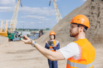 Drone industry inspection from pilot engineer. Team specialists operator inspecting construction building on open pit mine sand quarry