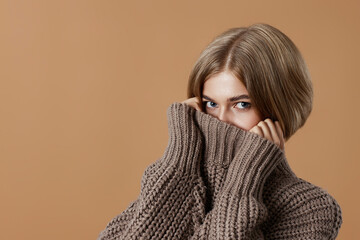beautiful blonde woman in brown knitted sweater