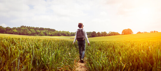 Rear view of a woman walking through a field