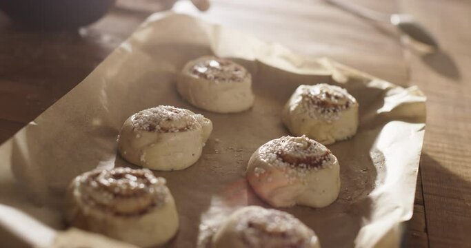 Close Up on Raw Cinnamon Roll Pastries with Sugar on a Plate for a Family and Friends Dinner for Christmas. Delicious Buns Being Prepared to be Cooked for Holiday Evening Guests