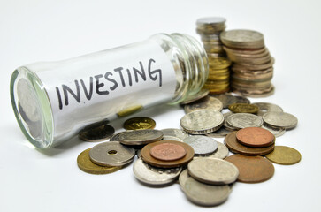 Investment lable in a glass jar with coins spilling out