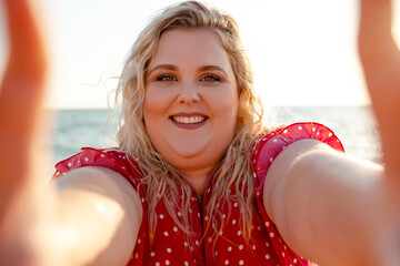 Plus size woman walking in the beach. The overweight woman dressed red dress. Happy moment of girl...