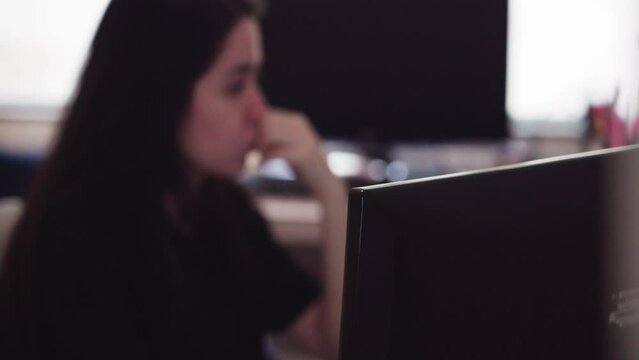 Woman with blur thinking on computer. Woman on computer working in office
