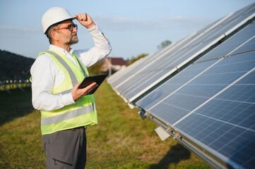 Senior engineer working on solar panel farm. The concept of green energy