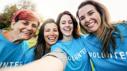 Happy group of volunteer people taking selfie picture at public park city - Teamwork and charity support concept