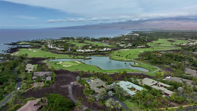 Aerial Kona Hawaii lava flow golf course tropical resort 2. Big Island. Luxury exclusive homes on coast with golf course. Volcanic lava flow environment. Economy is tourism.