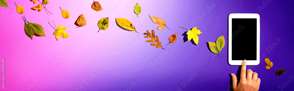 Poster autumn leaves with person using a tablet computer from above