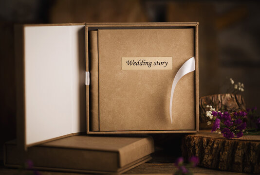 Photo book for wedding album on wood background. Wedding photo book, family album. Photo books with embossing and a cover of genuine leather. A book in an expensive binding.