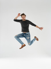 Full size of handsome guy jumping high rejoicing raising fists crazy competitive mood wear casual clothes isolated white background.