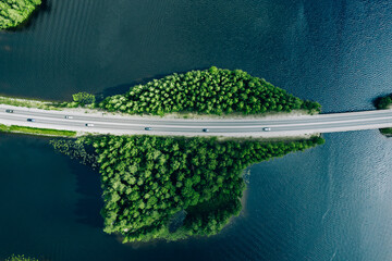  Aerial view of bridge road through blue lakes with green woods in Finland.