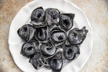 ravioli black color agnolotti cuttlefish ink fresh seafood salmon fish eating cooking appetizer meal food snack on the table copy space food background rustic top view