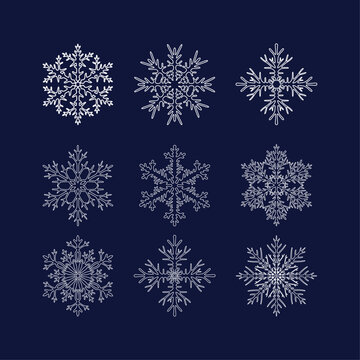 Set of nine complex different openwork smooth white snowflakes with a contour on a dark blue background