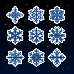 Stickers in the form of blue snowflakes with a light outline on the background of a beautiful starry sky