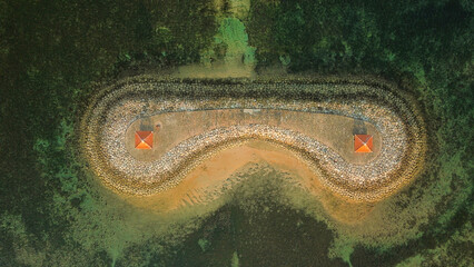 Aerial view of an artificially created island in the ocean off Sanur beach in Bali. There are two...