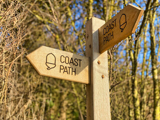 A wooden coast path signpost