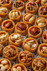 Bird's nest baklava with almonds, cashews, hazelnuts and pistachio. Turkish desert baklava with peanut for holiday or ramadan. Traditional Middle Eastern Flavors. Selective focus, pattern.