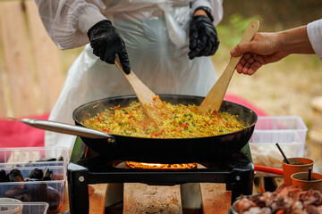A Cook stirs rice while preparing risotto.