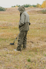 Man with electronic metal detector device working on outdoors.