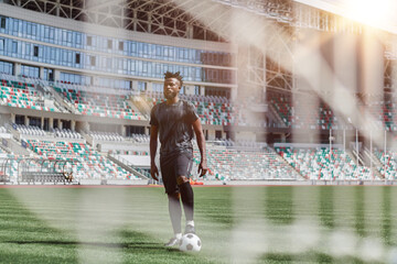 Young african american man holding soccer ball against soccer goal net - obrazy, fototapety, plakaty