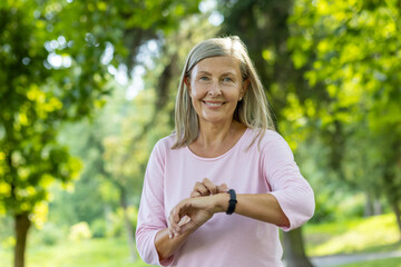 Close-up portrait of a beautiful senior woman exercising in the morning in the park, jogging and...