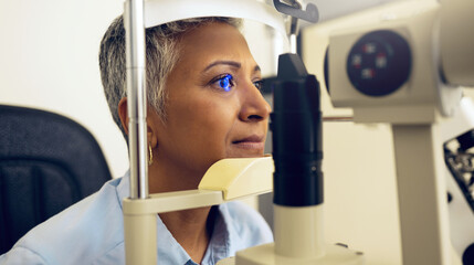 Eye test, machine and a woman for an optometry problem, scanning retina or surgery at a clinic. Healthcare, ophthalmology and a patient or person with an exam for vision, glasses or lens check