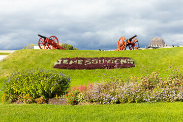 Two old red and black cannons looking over hill with the Quebec motto Je me souviens (I Remember)...