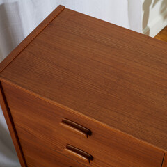 Vintage teak wood dresser. Mid-century modern gentleman's chest of drawers. Close-up detail of the...