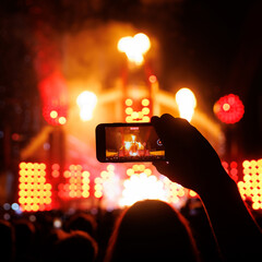 Fototapeta na wymiar People at concert shooting video or photo using mobile phones