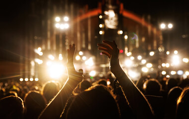 Applause for an artist's performance at a music concert. Raised hands silhouette close-up.