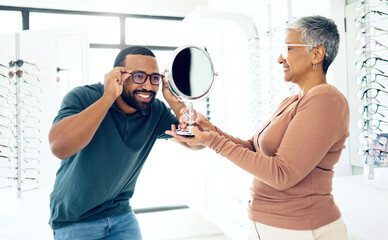 Mirror, glasses and optometrist help happy man in store for choice of lens, frame and consultation. Smile, reflection and mature optician with patient for spectacles, healthy vision and ophthalmology - obrazy, fototapety, plakaty