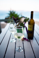 White wine served on a cold wineglass on a wooden table in Santorini, Greece