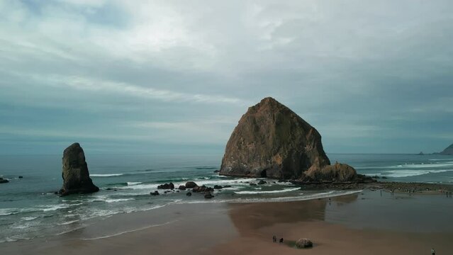 Wide Aerial shot of Haystack Rock beach in coastal town Cannon Beach, Oregon. Wide drone shot 