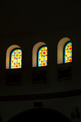 Large stained glass window with frescoes and Arabic hieroglyph in the hall inside the mosque