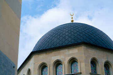 Close-up shot of the gambiz dome with a crescent moon on top of a Muslim mosque against blue sky