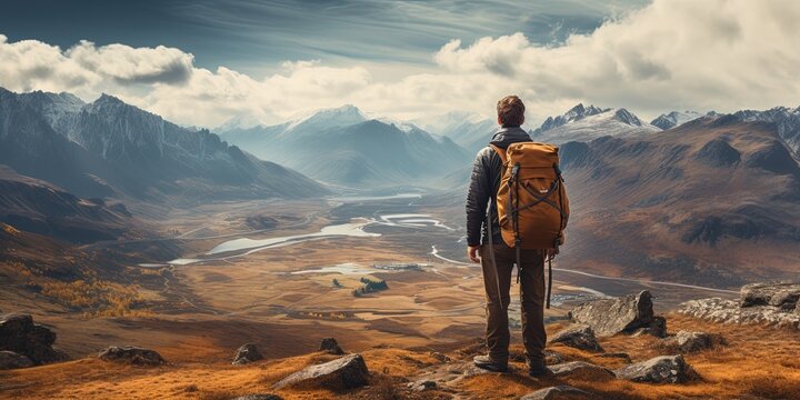 Men with backpack standing on the top of mountain and enjoying the view. Travel concept. Achieving your dreams.