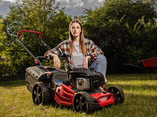 Female gardener working in autumn, cutting grass in backyard. Concept of gardening, work, nature....