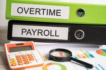Overtime., Payroll Binder data finance report business with graph analysis in office.