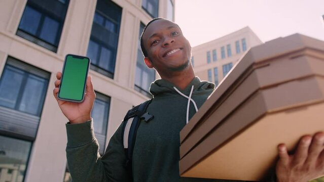 Pizza delivery man with a green screen mobile phone on a sunny summer day