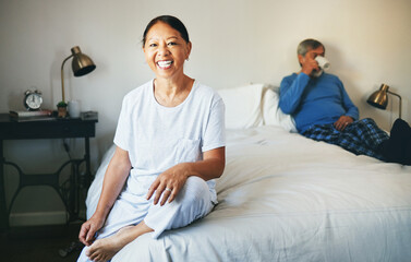 Fototapeta premium Portrait, smile and a senior asian woman on her bed in her retirement with her husband drinking coffee. Relax, bedroom and a happy elderly person in her home or hotel room for hospitality together