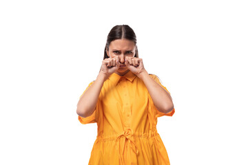 young brunette woman dressed in a summer yellow dress is distressed and wants to cry