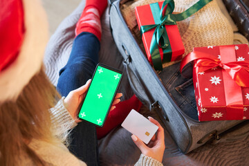 Mockup of smartphone and payment card. A woman pays for a holiday trip or buys gifts online.