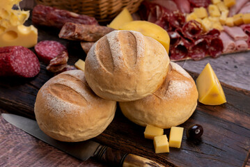 chopping board of cheeses and salami cold cuts of various varieties homemade country bread with almonds and handmade knife
