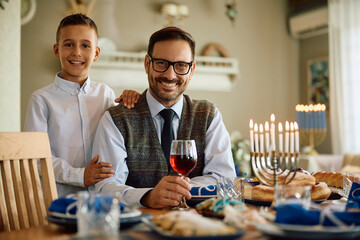 Happy Jewish father and son on Hanukkah at home looking at camera.