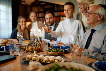 Close up of lighting menorah during family meal on Hanukkah.