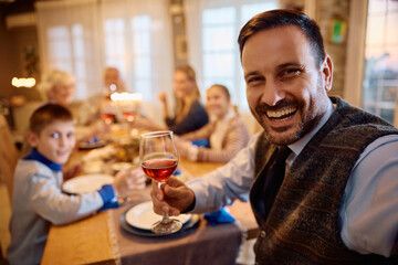 Happy man taking selfie while celebrating Hanukkah with his family.