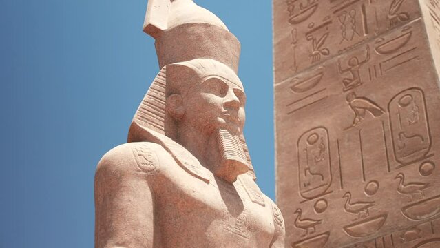 Replica of the Egyptian pharaoh statue and obelisk with hieroglyphs in the background. The remains of ancient civilization