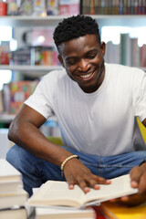A focused young student in a university library, engrossed in academic pursuits, surrounded by books and knowledge.